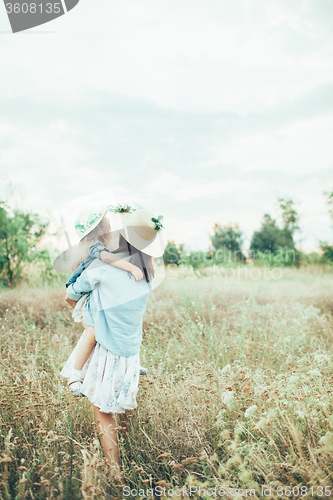 Image of The young mother and daughter on green grass background 