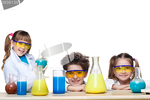 Image of The three cute children at chemistry lesson making experiments on white background