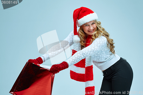 Image of Beautiful young woman in Santa Claus clothes