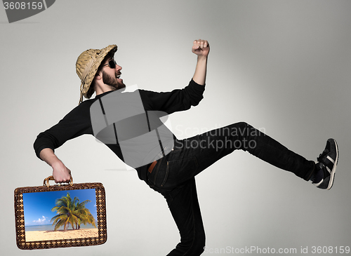 Image of Young, attractive man  in sunglasses with  suitcase ready to travel 