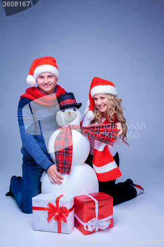 Image of Lovely christmas couple sitting with presents