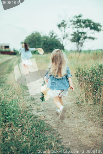 Image of The young mother and daughter on green grass background 