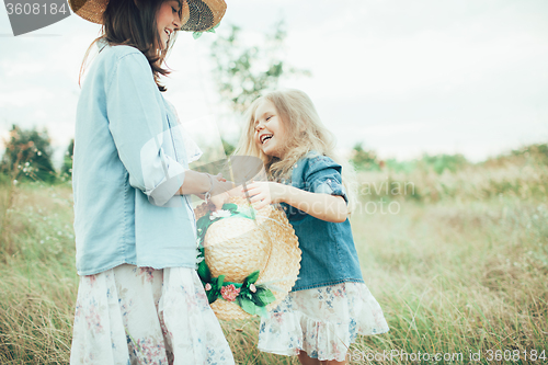 Image of The young mother and daughter on green grass background 