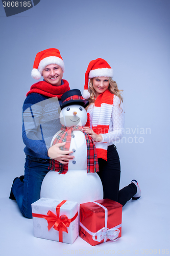 Image of Lovely christmas couple sitting with presents