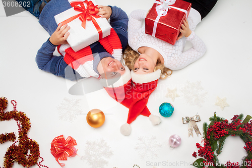 Image of Lovely christmas couple lying with presents