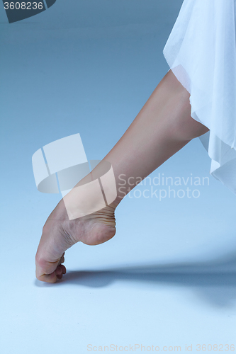 Image of Close-up ballerina\'s leg on the blue floor 