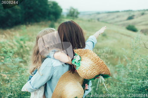 Image of The young mother and daughter on green grass background 