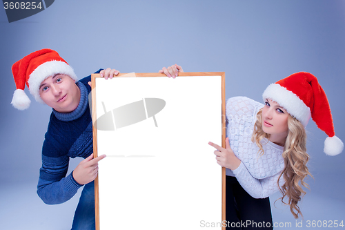 Image of Christmas couple holding white board with empty copy space 