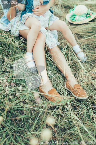 Image of The young mother and daughter on green grass background 