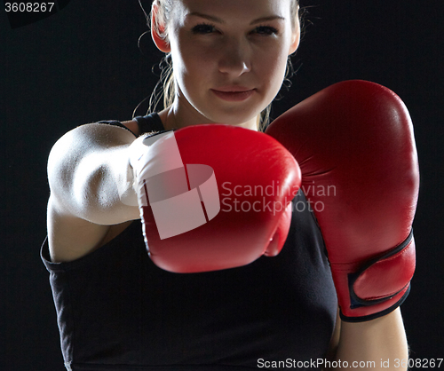 Image of beautiful woman is boxing on gray background