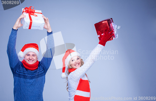 Image of Lovely christmas couple holding presents