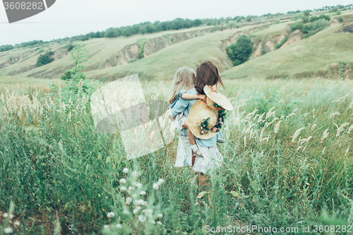 Image of The young mother and daughter on green grass background 