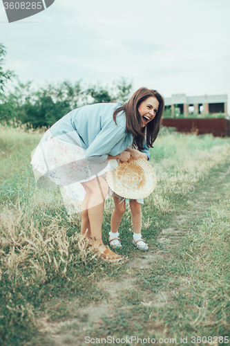 Image of The young mother and daughter on green grass background 