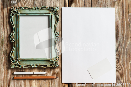 Image of The mockup on wooden background with vintage old picture frame