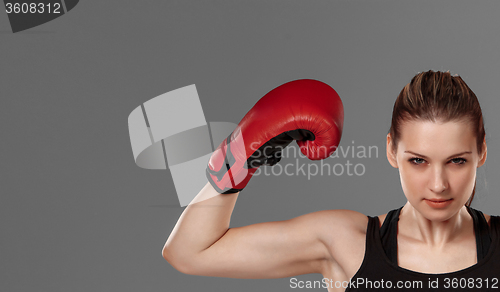 Image of Beautiful winner. Blond hair woman in red boxing gloves standing on gray background