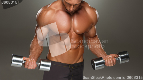 Image of athletic man bodybuilder doing exercises with dumbbell 