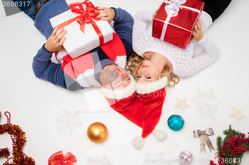 Image of Lovely christmas couple lying with presents