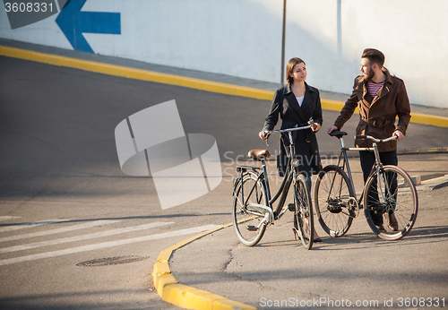 Image of Young couple with on a bicycle opposite city 