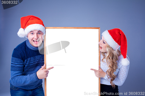 Image of Christmas couple holding white board with empty copy space 