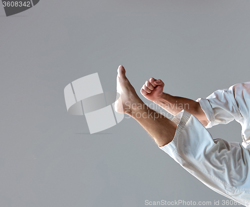 Image of Man in white kimono training karate