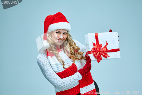 Image of Beautiful young woman in Santa Claus clothes