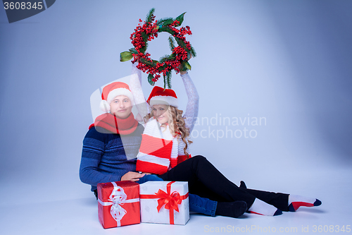 Image of Lovely christmas couple sitting with presents