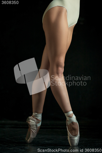 Image of The close-up feet of young ballerina in pointe shoes 