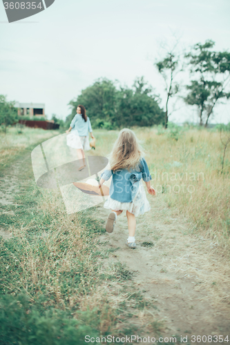 Image of The young mother and daughter on green grass background 