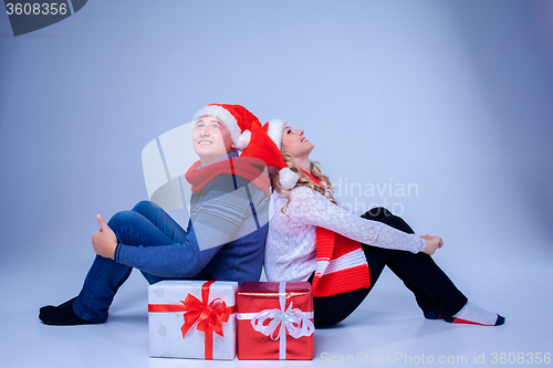 Image of Lovely christmas couple sitting with presents