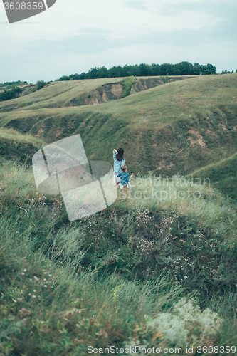 Image of The young mother and daughter on green grass background 