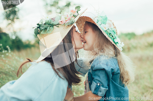 Image of The young mother and daughter on green grass background 