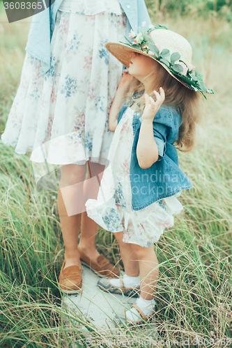 Image of The young mother and daughter on green grass background 