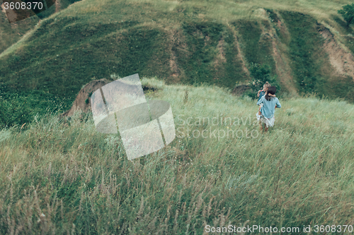 Image of The young mother and daughter on green grass background 