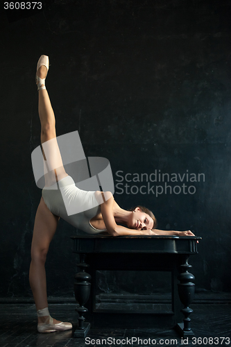 Image of The beautiful ballerina posing against  dark background