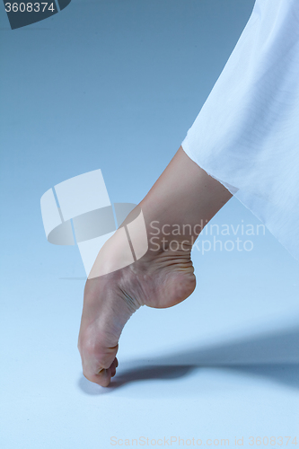 Image of Close-up ballerina\'s leg on the blue floor 