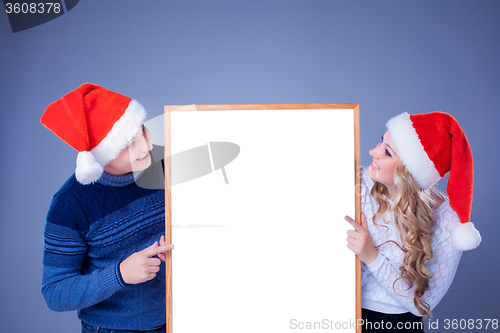 Image of Christmas couple holding white board with empty copy space 