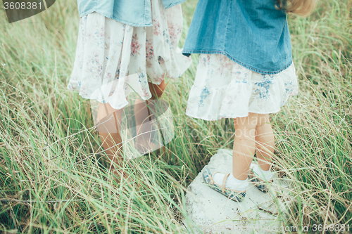 Image of The young mother and daughter on green grass background 