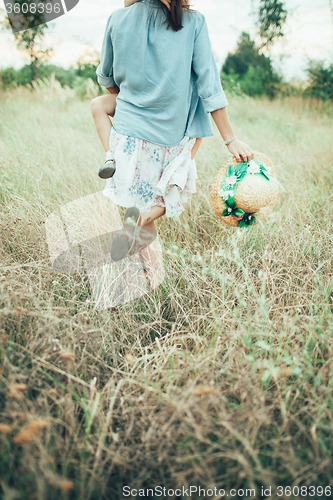 Image of The young mother and daughter on green grass background 