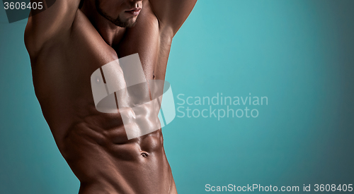 Image of Attractive male body builder on blue background