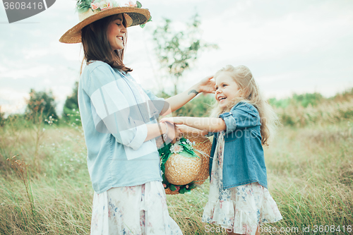 Image of The young mother and daughter on green grass background 