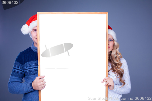 Image of Christmas couple holding white board with empty copy space 