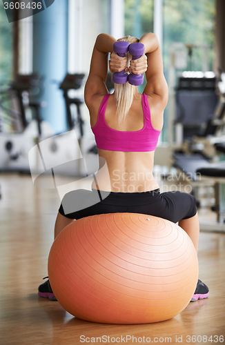 Image of lifting some weights and working on her biceps in a gym