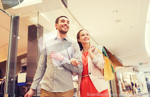 Image of happy young couple with shopping bags in mall