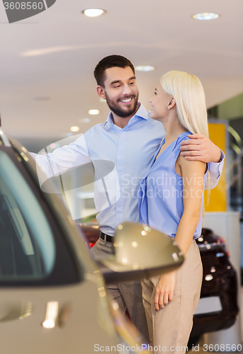 Image of happy couple buying car in auto show or salon