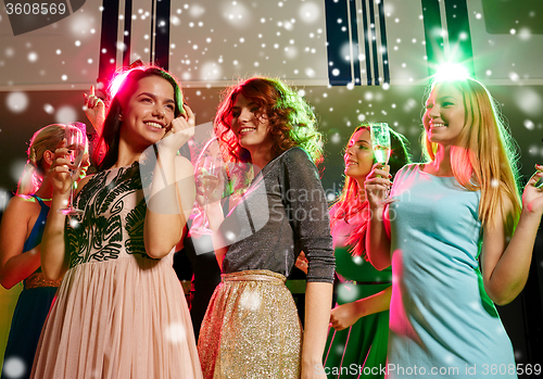 Image of smiling friends with glasses of champagne in club