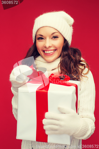 Image of smiling woman in white clothes with gift box