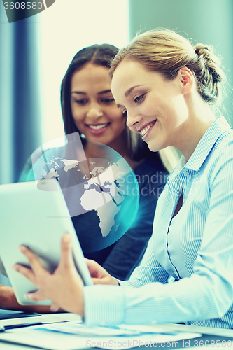 Image of smiling businesswomen with tablet pc in office