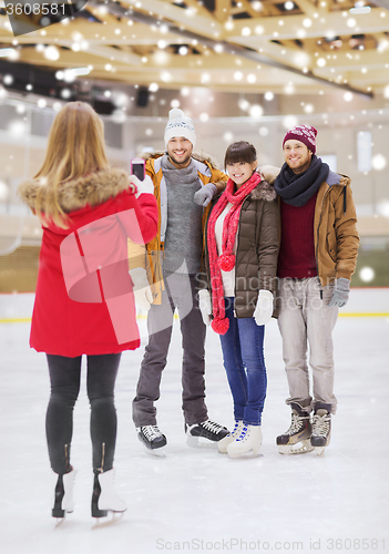 Image of happy friends taking photo on skating rink