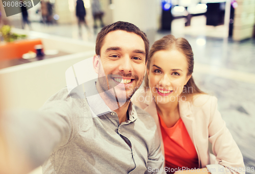Image of happy couple taking selfie in mall or office