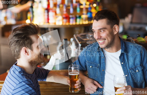 Image of happy male friends drinking beer at bar or pub